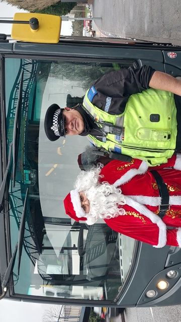PCSO meets a bus driver dressed as Santa standing in front of a bus. 